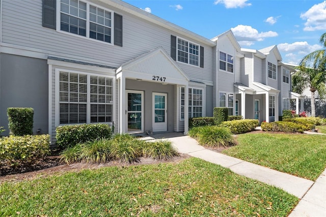 townhome / multi-family property featuring a front yard