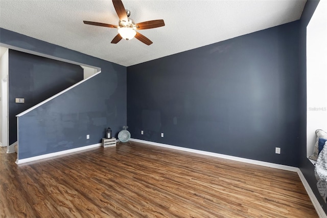 spare room featuring wood finished floors, a ceiling fan, baseboards, and a textured ceiling