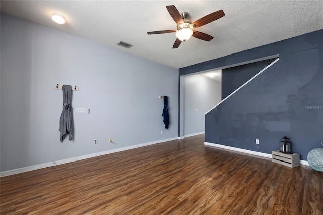 spare room featuring visible vents, a ceiling fan, a textured ceiling, wood finished floors, and baseboards