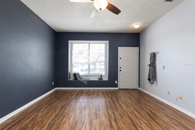 spare room with baseboards, wood finished floors, and a ceiling fan