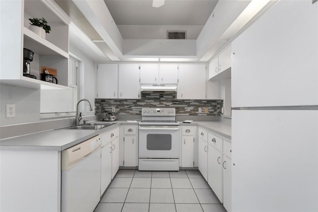 kitchen featuring white appliances, visible vents, light tile patterned flooring, a sink, and under cabinet range hood