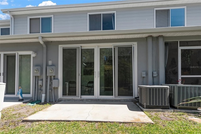 rear view of property featuring a patio, cooling unit, and french doors