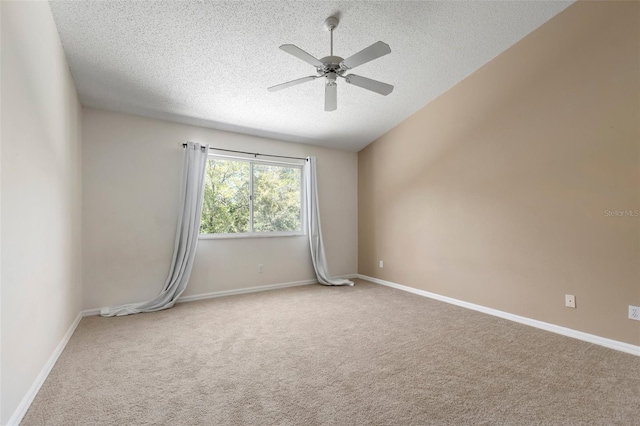 carpeted spare room featuring baseboards, a textured ceiling, and a ceiling fan