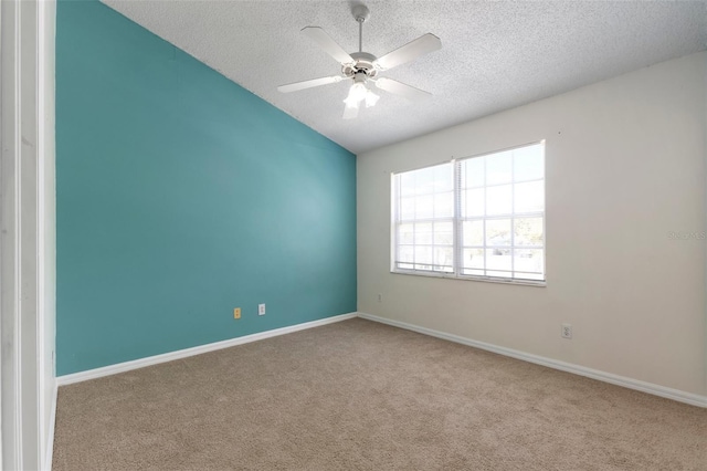 empty room with baseboards, a textured ceiling, ceiling fan, and carpet