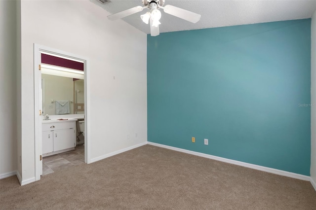 unfurnished bedroom with connected bathroom, ceiling fan, baseboards, light carpet, and a sink