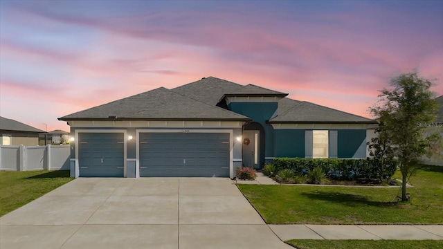 view of front facade with a front lawn, an attached garage, fence, and driveway