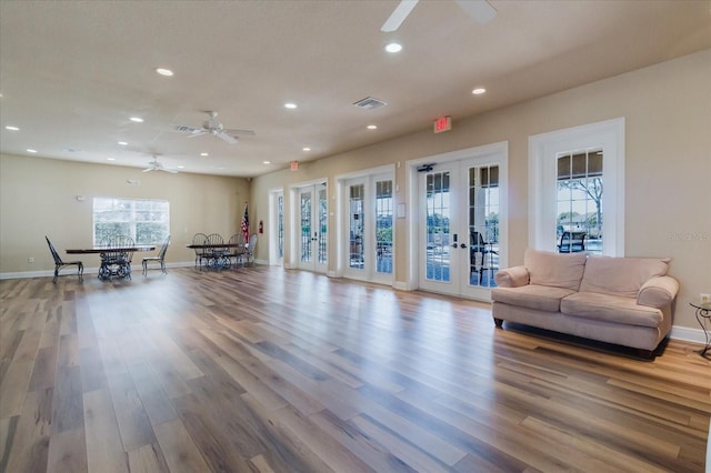 sitting room featuring wood finished floors, visible vents, baseboards, recessed lighting, and french doors