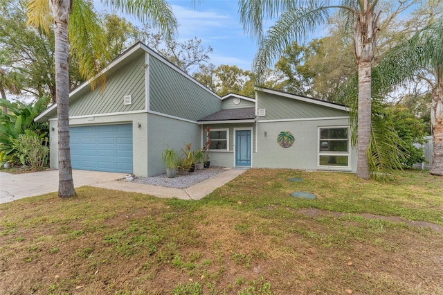 mid-century home featuring a garage, concrete driveway, a front lawn, and stucco siding