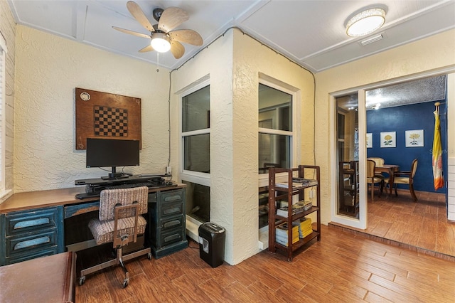 office with ceiling fan, a textured wall, and wood finished floors