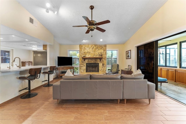 living area featuring lofted ceiling, visible vents, and a wealth of natural light