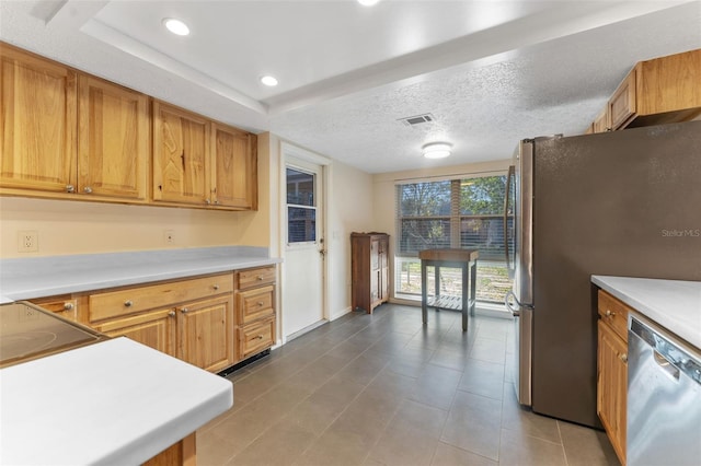 kitchen featuring a textured ceiling, recessed lighting, stainless steel appliances, visible vents, and light countertops