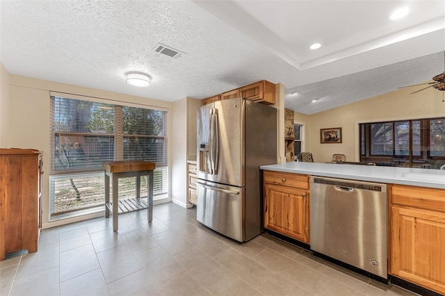 kitchen featuring lofted ceiling, recessed lighting, light countertops, visible vents, and appliances with stainless steel finishes