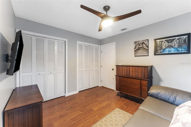 interior space with baseboards, wood finished floors, visible vents, and a ceiling fan