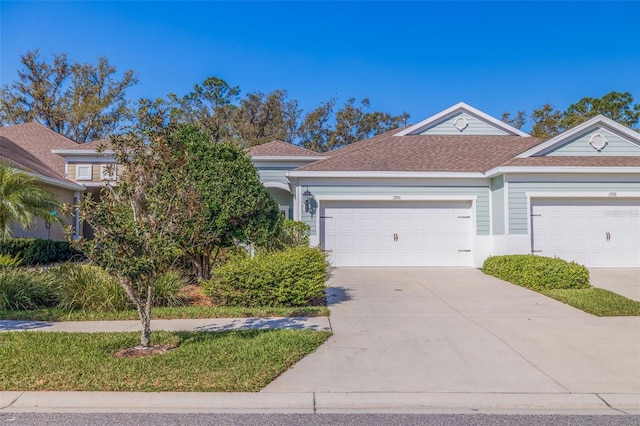 view of front of home with concrete driveway and a shingled roof