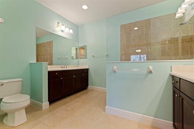 full bath featuring toilet, vanity, a walk in shower, baseboards, and tile patterned floors