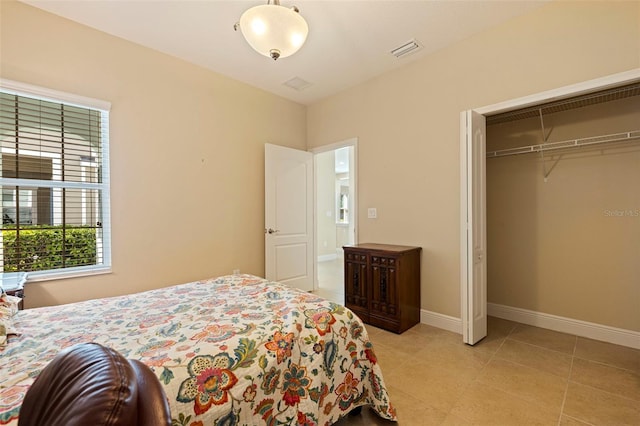 bedroom featuring light tile patterned floors, baseboards, visible vents, and a closet