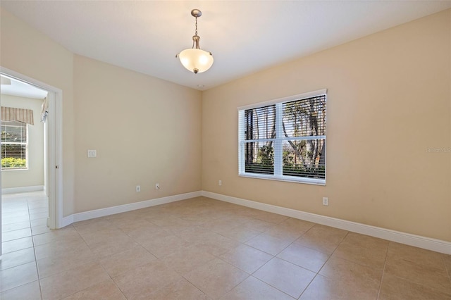 unfurnished room with light tile patterned flooring and baseboards