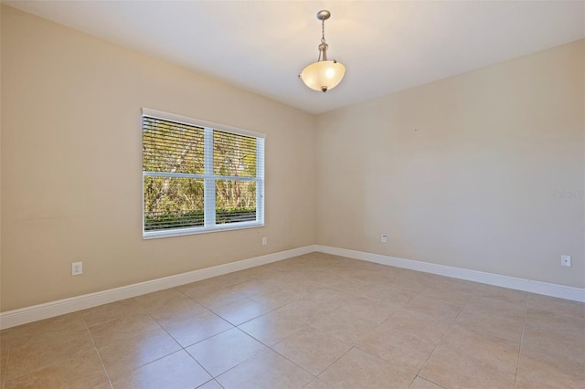 empty room with light tile patterned flooring and baseboards