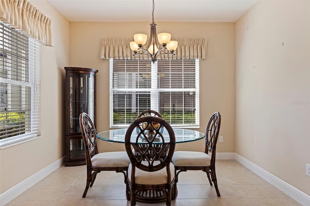 dining area featuring a notable chandelier, baseboards, and light tile patterned floors