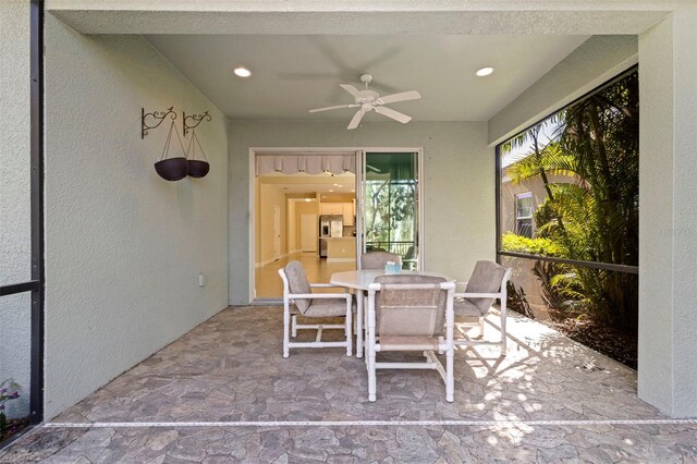 sunroom / solarium featuring a ceiling fan