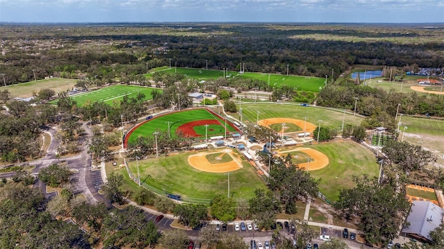 drone / aerial view with view of golf course and a forest view