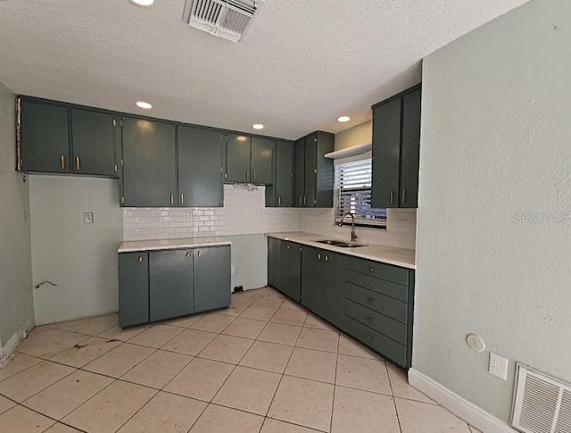 kitchen with tasteful backsplash, light tile patterned flooring, a sink, and visible vents