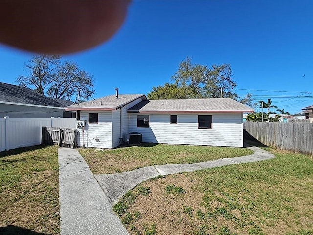 view of front facade with a front yard, fence, and cooling unit