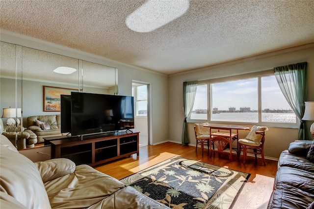 living area with crown molding, a textured ceiling, baseboards, and wood finished floors