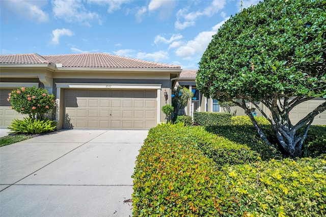 view of front of home with concrete driveway, a tiled roof, and stucco siding