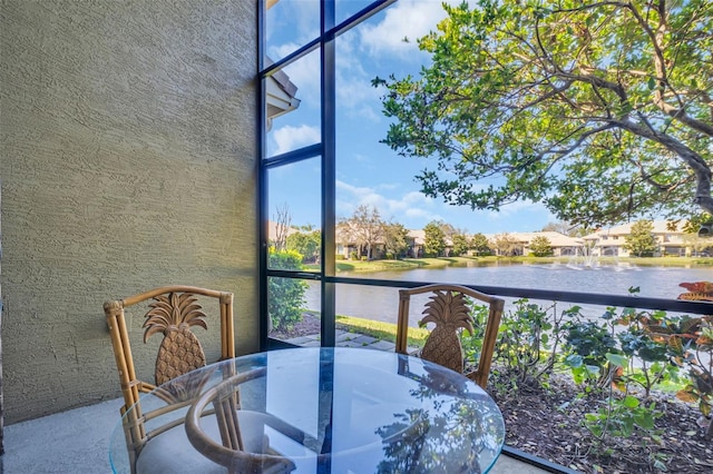 sunroom featuring a water view