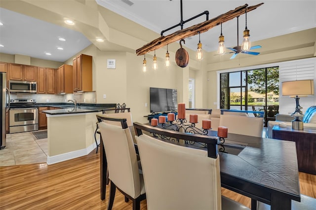 dining room with light wood-type flooring, a ceiling fan, and recessed lighting