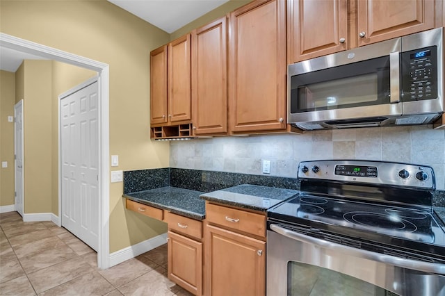 kitchen with baseboards, appliances with stainless steel finishes, light tile patterned flooring, and tasteful backsplash