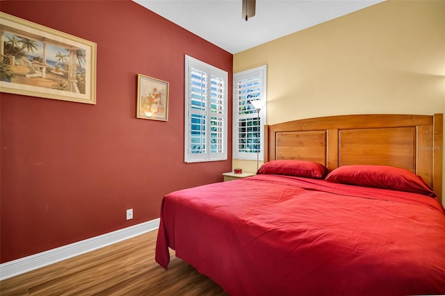 bedroom featuring ceiling fan, wood finished floors, and baseboards