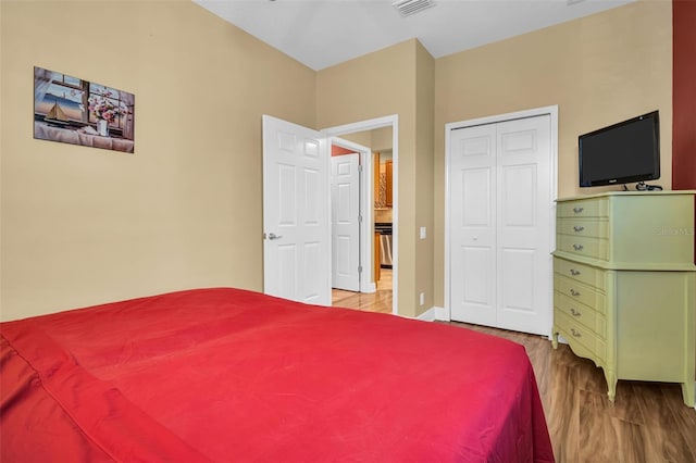 bedroom featuring a closet, wood finished floors, and visible vents