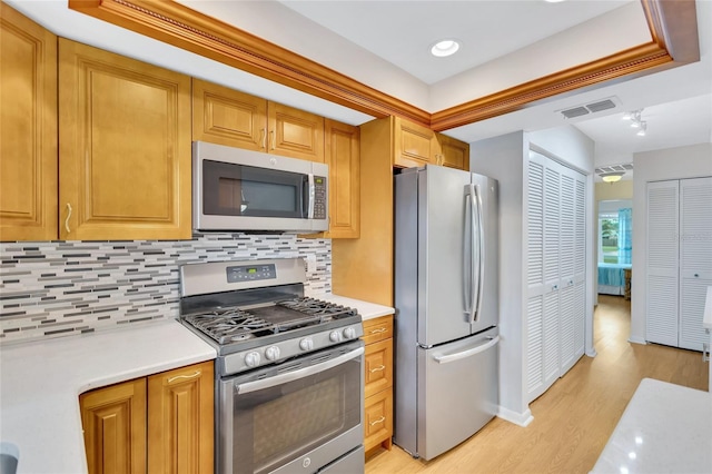 11430 94th St, Largo, FL 33773 - kitchen featuring light countertops, appliances with stainless steel finishes, light wood-style flooring, visible vents, and decorative backsplash