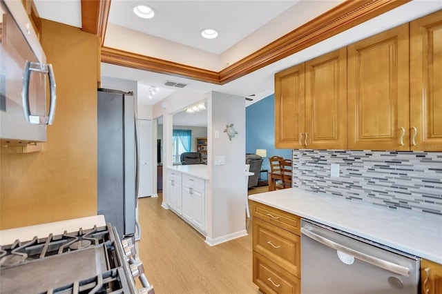 11430 94th St, Largo, FL 33773 - kitchen with light countertops, backsplash, light wood-style floors, visible vents, and appliances with stainless steel finishes