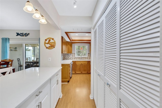 11430 94th St, Largo, FL 33773 - kitchen with light countertops, a sink, light wood finished floors, dishwasher, and decorative backsplash