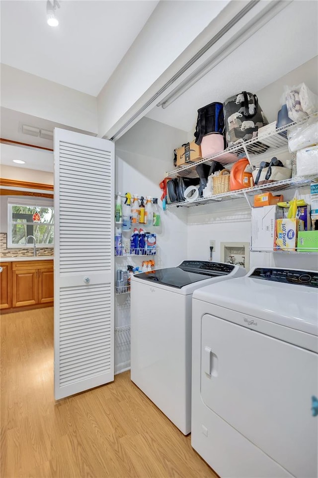 11430 94th St, Largo, FL 33773 - laundry room with a sink, washer and clothes dryer, laundry area, and light wood-type flooring