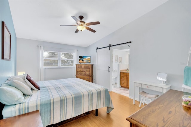 11430 94th St, Largo, FL 33773 - bedroom with vaulted ceiling, light wood-type flooring, ensuite bath, a barn door, and a ceiling fan
