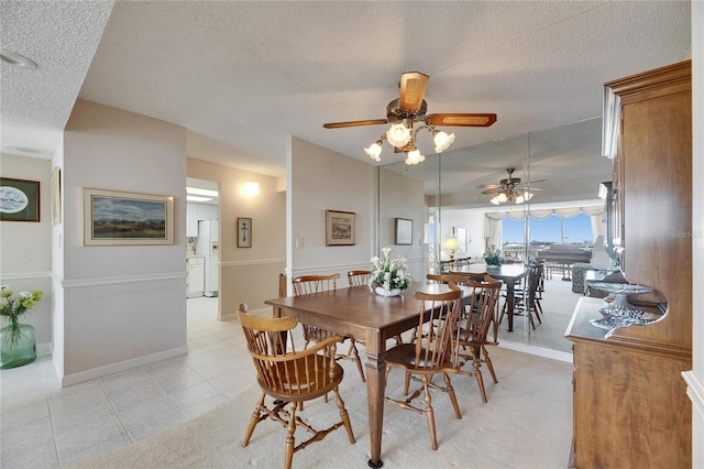 dining room featuring light tile patterned flooring, a textured ceiling, and baseboards