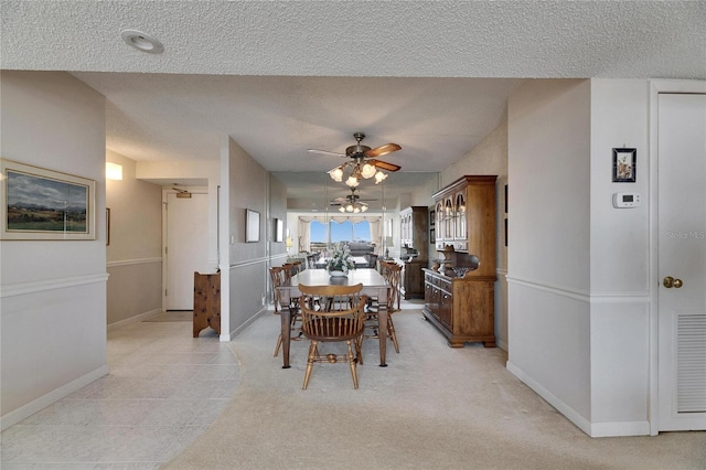 dining area featuring visible vents, ceiling fan, a textured ceiling, and baseboards