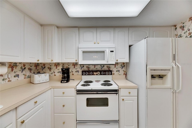 kitchen with white appliances, white cabinetry, and wallpapered walls