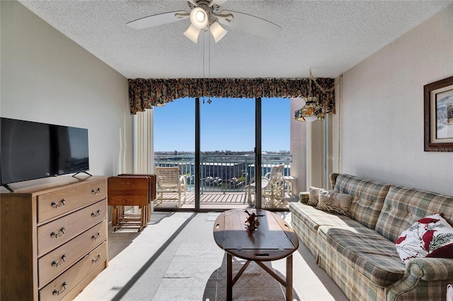 living room with carpet floors, a textured ceiling, and a ceiling fan