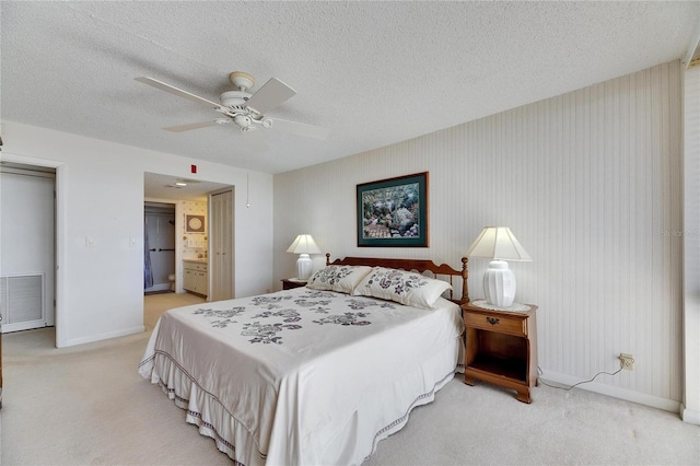 bedroom with baseboards, visible vents, light carpet, and a textured ceiling