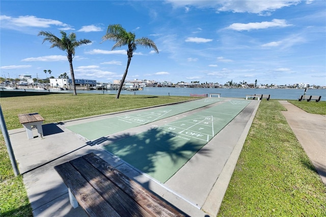 view of community with shuffleboard, a lawn, and a water view