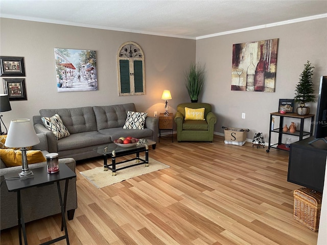 living area with light wood-style floors, ornamental molding, and baseboards