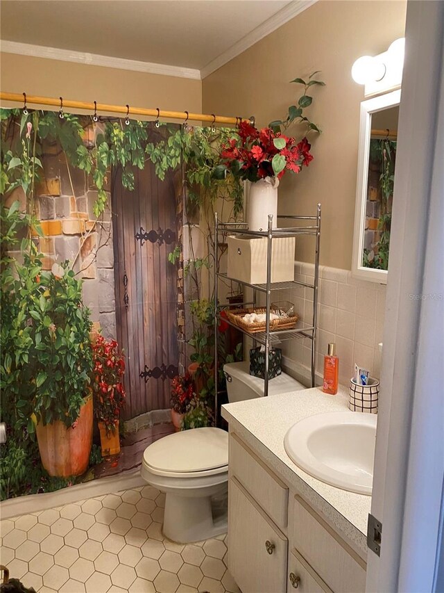 bathroom with toilet, tile walls, vanity, wainscoting, and crown molding