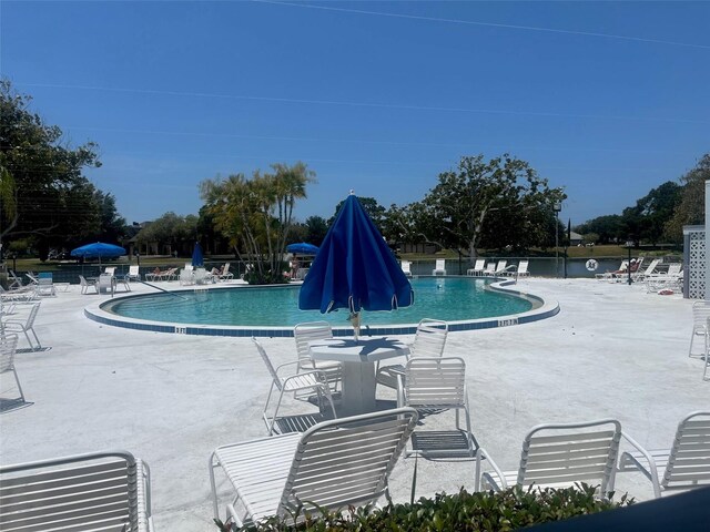 pool with a patio area and fence