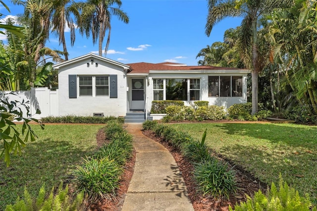 view of front of house with a front yard, fence, and stucco siding