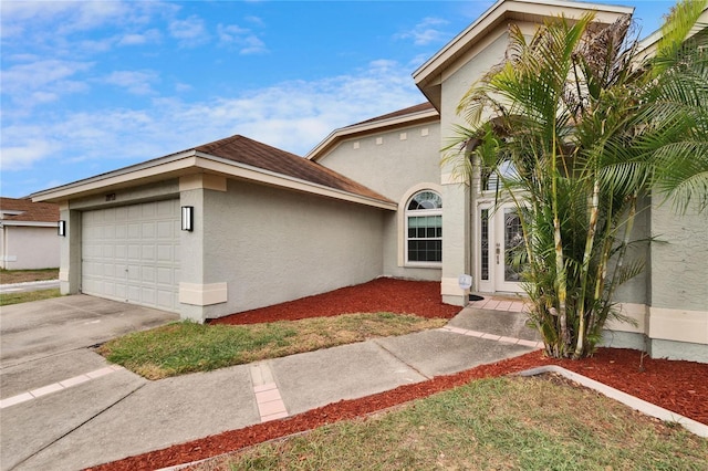 view of front of house with a garage, driveway, and stucco siding